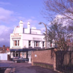 Mead Path, Colliers Wood, London SW19. Mitchamingemerke. Looking across Plough Lane towards the White Lion and Summerstown (Tooting SW17). Sign of the Plough on left.