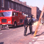 Aftermath of fire and explosion at Calorgas storage premises, Church Road, Mitcham, Surrey CR4. Firemen clearing metal fragments from shattered gas cylinders after fire.